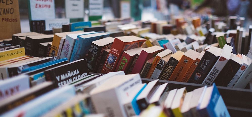 Kisten mit vielen bunten gebrauchten Büchern.