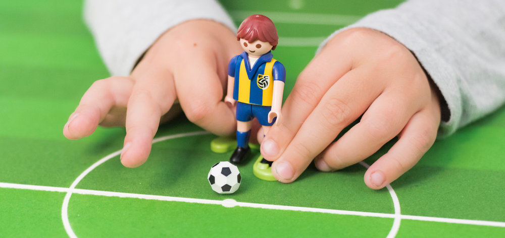 Kinderhände spielen Tischfußball